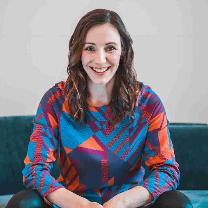 Bettina Ludwig im bunten Shirt auf dem Sofa in Vorbereitung auf ihren Talk zum Thema Positive Psychologie