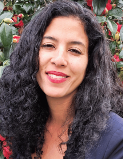 Alexandra Reyes, Deutsche Bank steht vor einem blühenden Strauch im Rahmen ihrer Keynote zu Mindfulness und Resilienz